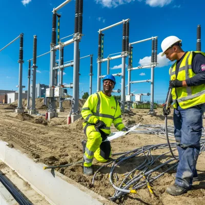 2 mannen aan het werk bij de bouw van een 150KV station